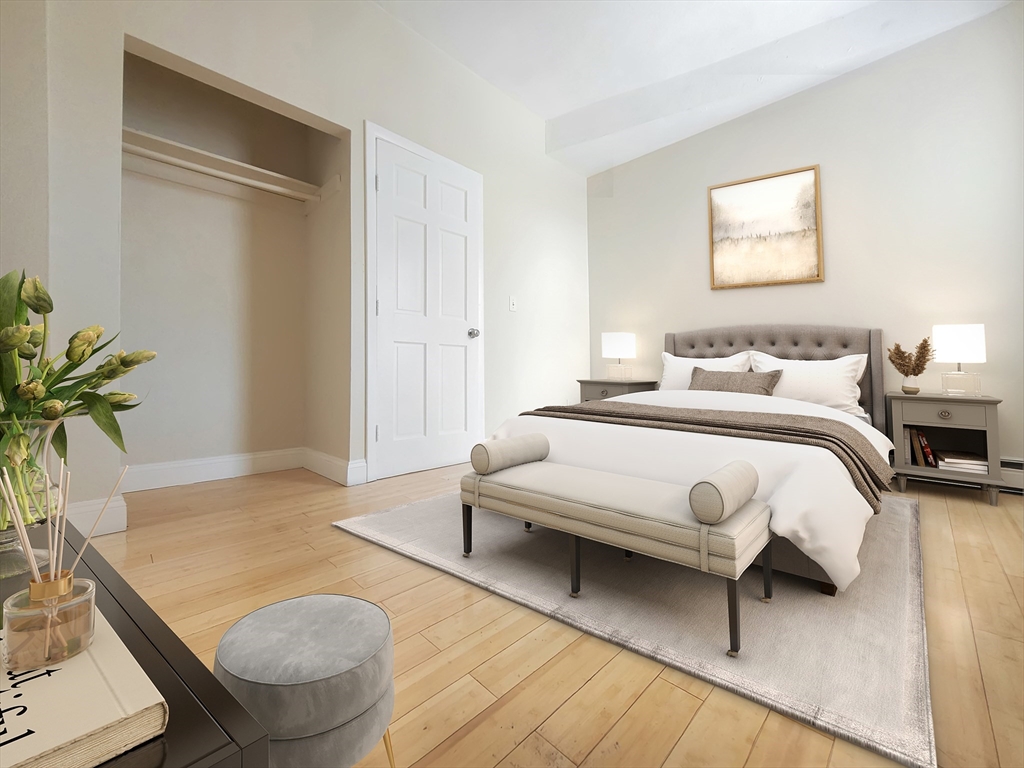 338-342 Warren Street, Unit 3 Boston, MA 02119 - Photo 4 of 7 a bedroom with a bed and a potted plant