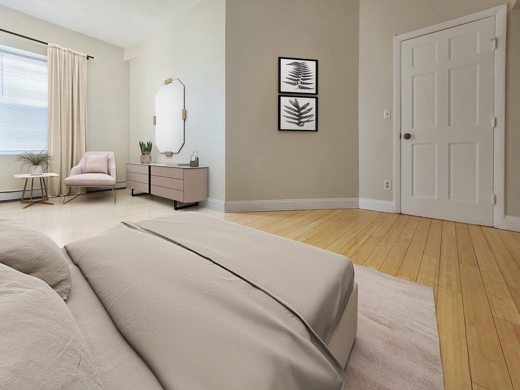 338-342 Warren Street, Unit 3 Boston, MA 02119 - Photo 6 of 7 a spacious bedroom with a bed a couch and a window