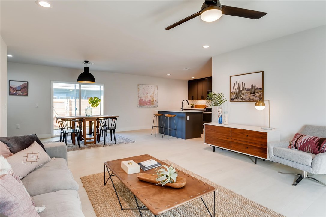a living room with furniture kitchen view and a chandelier