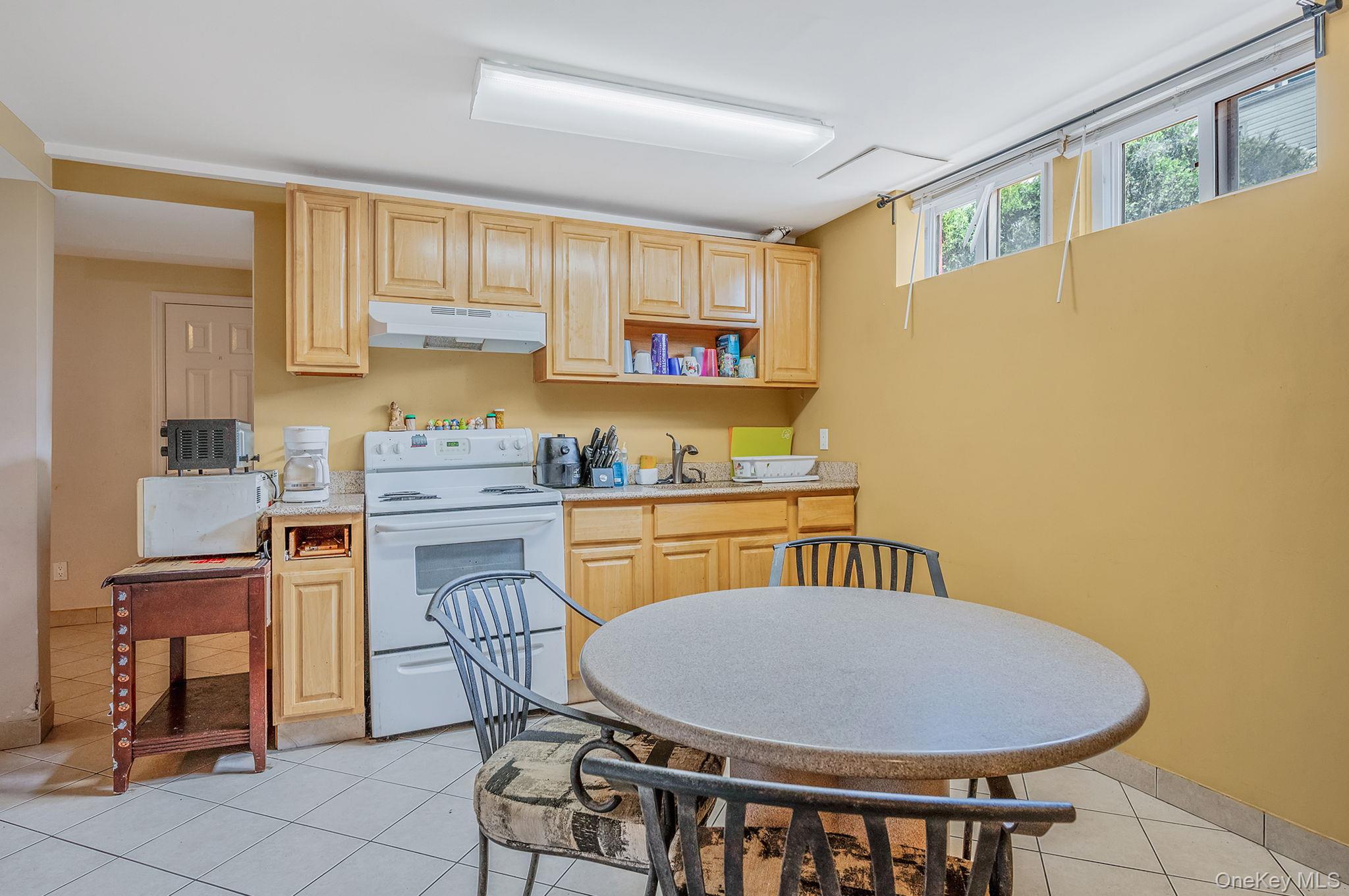557 Newbridge Road East Meadow, NY 11554 - Photo 13 of 31 a kitchen with a dining table chairs and a refrigerator