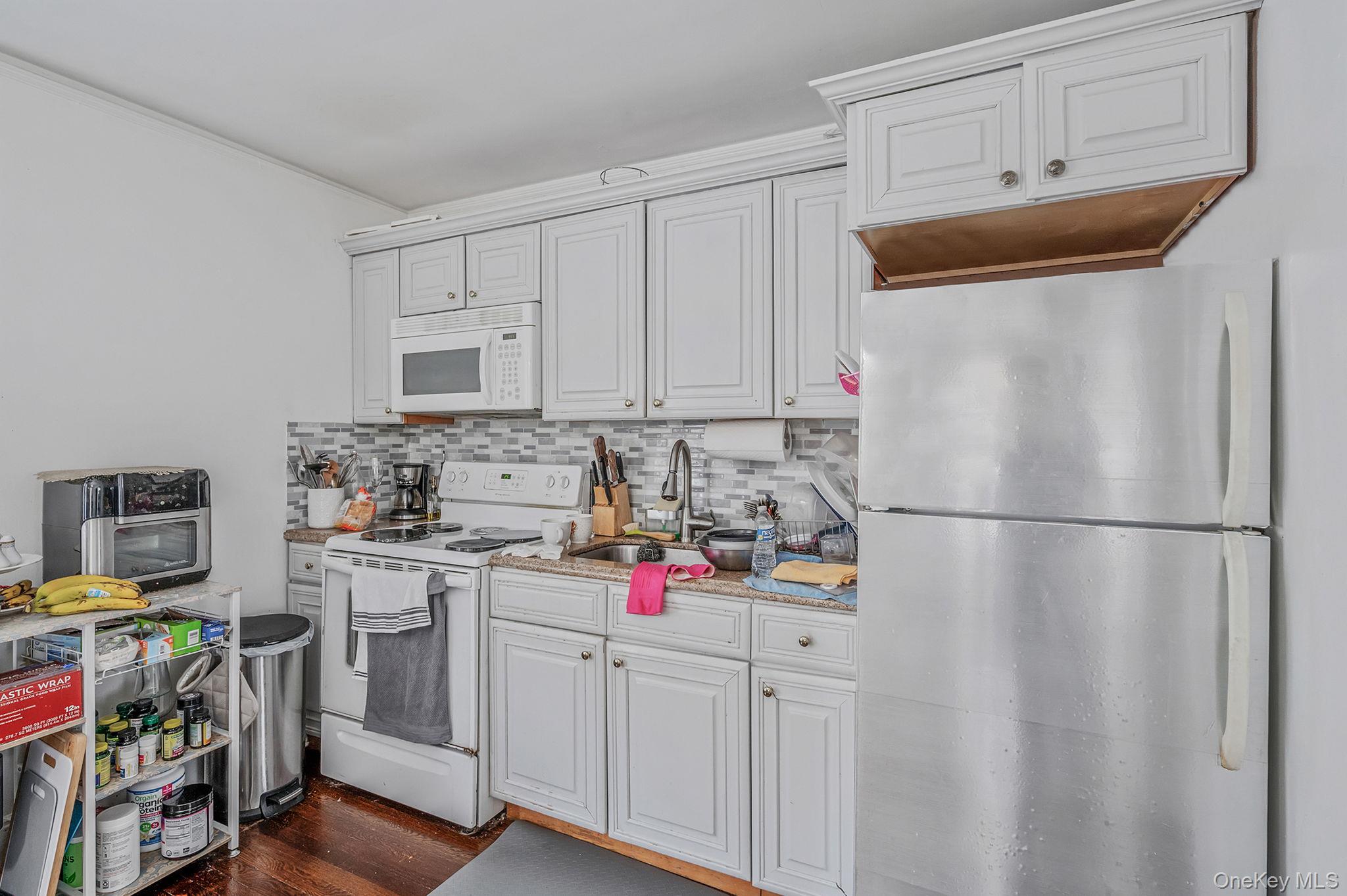557 Newbridge Road East Meadow, NY 11554 - Photo 21 of 31 a kitchen with refrigerator a stove a sink and cabinets