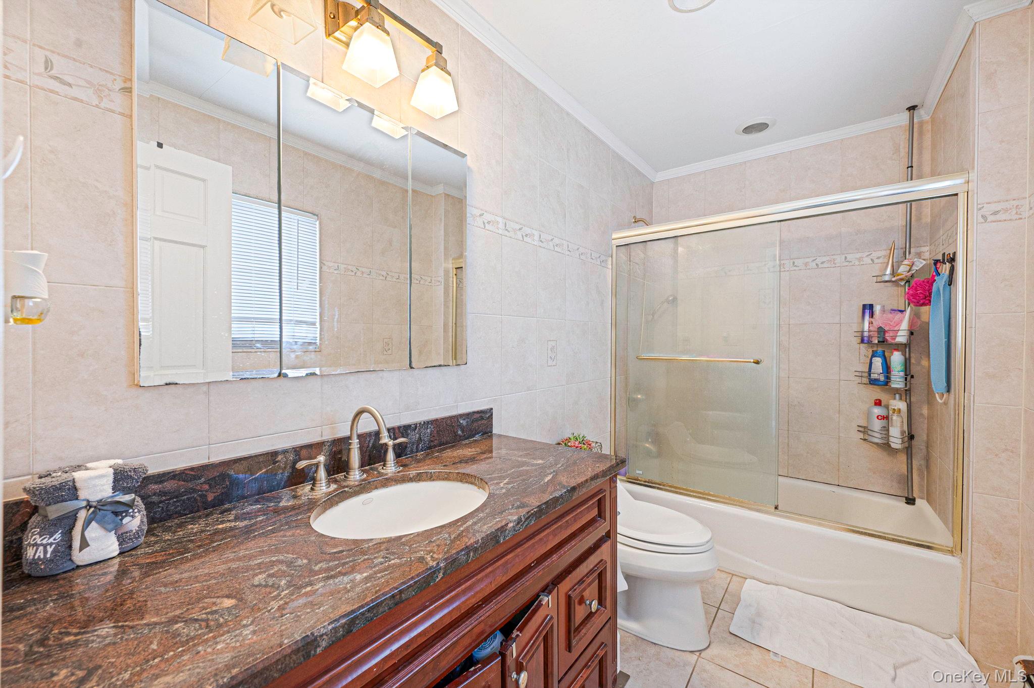 557 Newbridge Road East Meadow, NY 11554 - Photo 22 of 31 a bathroom with a granite countertop sink a toilet a mirror and shower