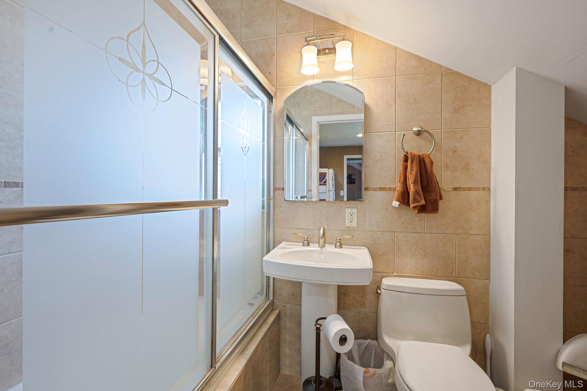 557 Newbridge Road East Meadow, NY 11554 - Photo 9 of 31 a bathroom with a sink a toilet and mirror