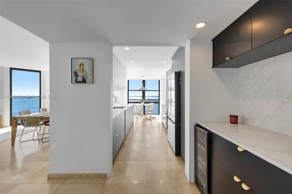 a living room with stainless steel appliances furniture and a large window