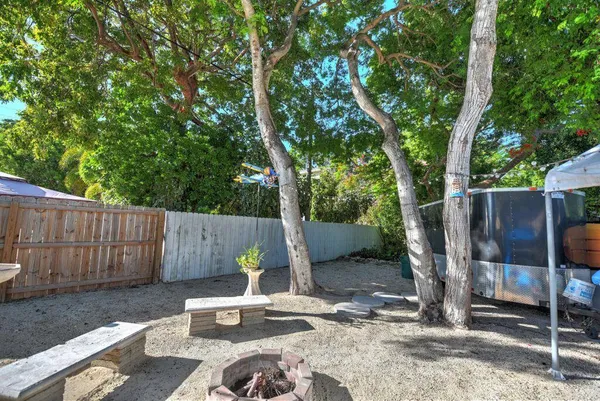 a view of a backyard with a patio and wooden fence