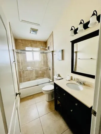 a bathroom with a double vanity sink toilet mirror and shower