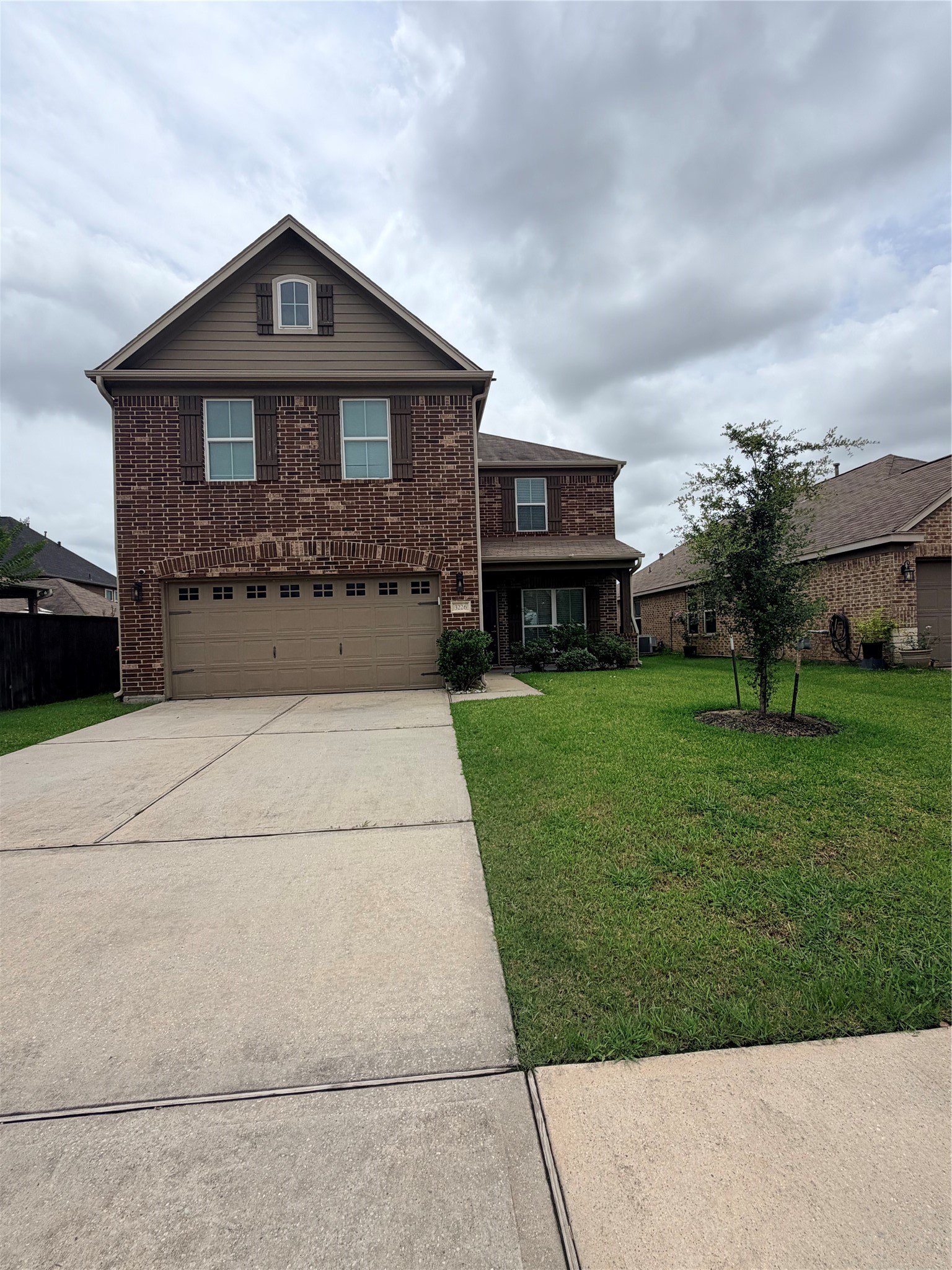 3226 Dappled Vale Trail Spring, TX 77373 - Photo 4 of 26 This home features a two-story brick exterior with a two-car garage, a well-maintained lawn, and a spacious driveway. The front entry is accented with shrubs and a small tree, offering great curb appeal.