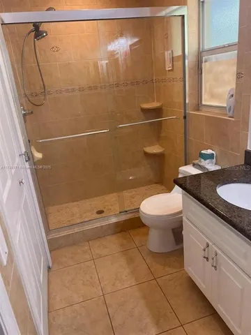 a bathroom with a granite countertop sink toilet and a shower