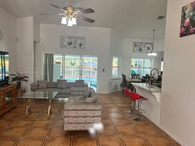 a living room with furniture a chandelier and a dining table