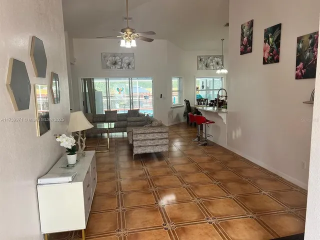 a living room with patio furniture and a chandelier