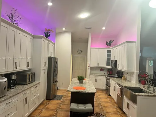 a kitchen with stainless steel appliances kitchen island granite countertop a refrigerator and a stove