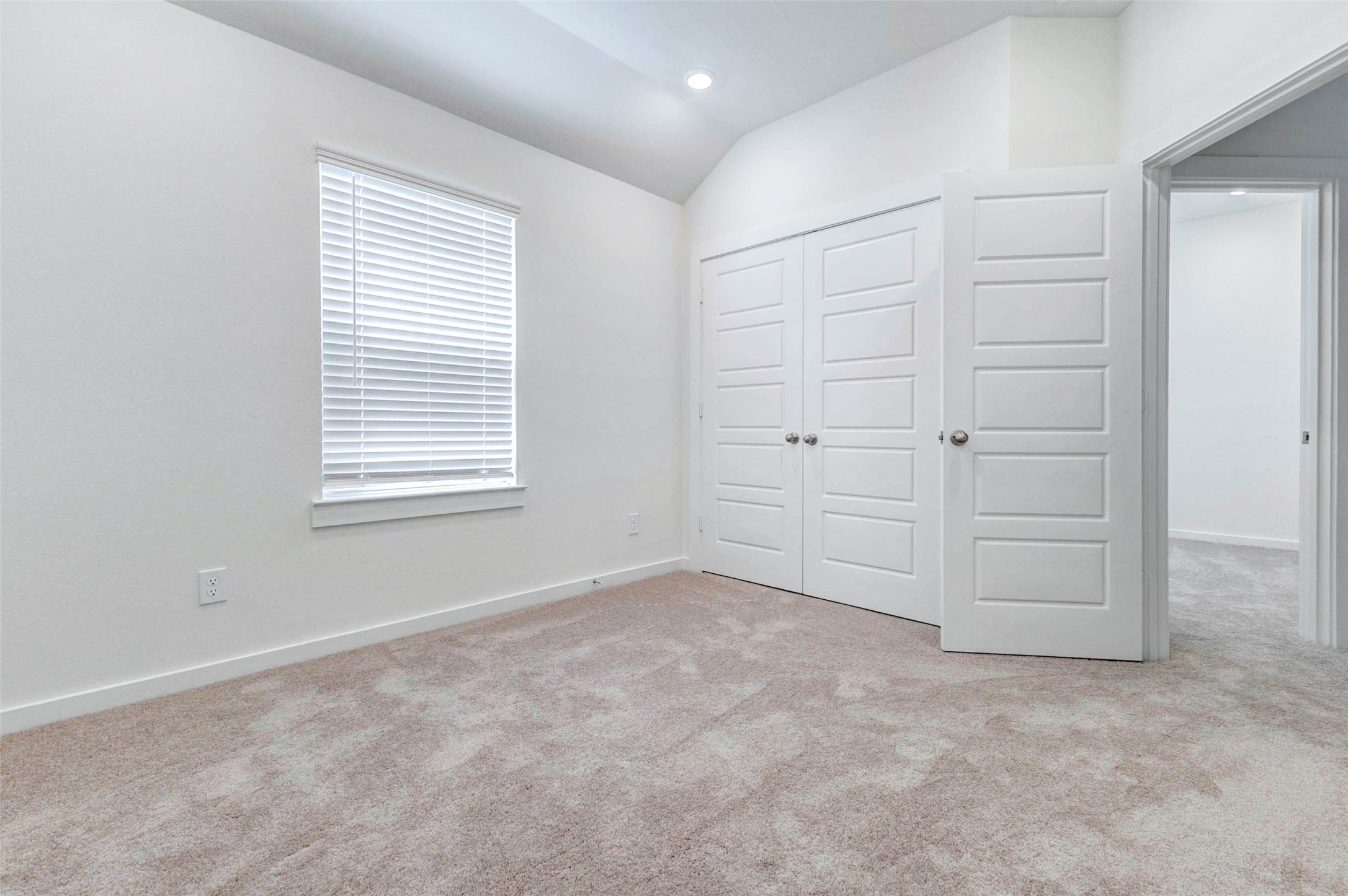 6475 Escondido Drive Rosharon, TX 77583 - Photo 25 of 32 This bedroom features a bright window with blinds, soft carpet, high ceilings, and a double-door closet for added storage. The neutral color palette and clean finishes create a fresh, welcoming space that can easily fit a variety of furniture layouts and personal styles.