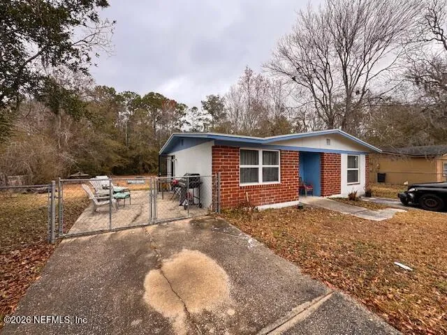 a view of a house with backyard and chairs