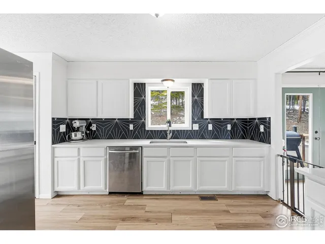 a kitchen with a refrigerator and white cabinets