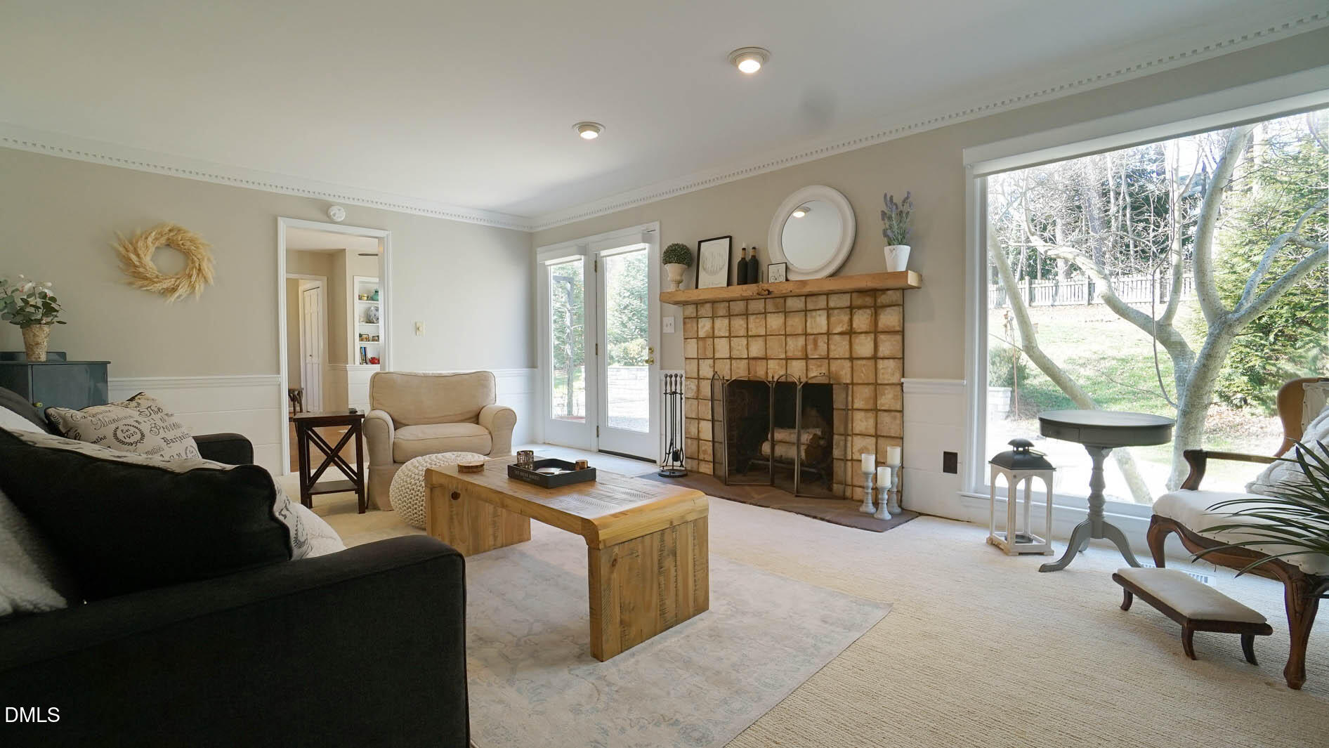 8613 Windjammer Drive Raleigh, NC 27615 - Photo 12 of 52 a living room with furniture a fireplace and a floor to ceiling window