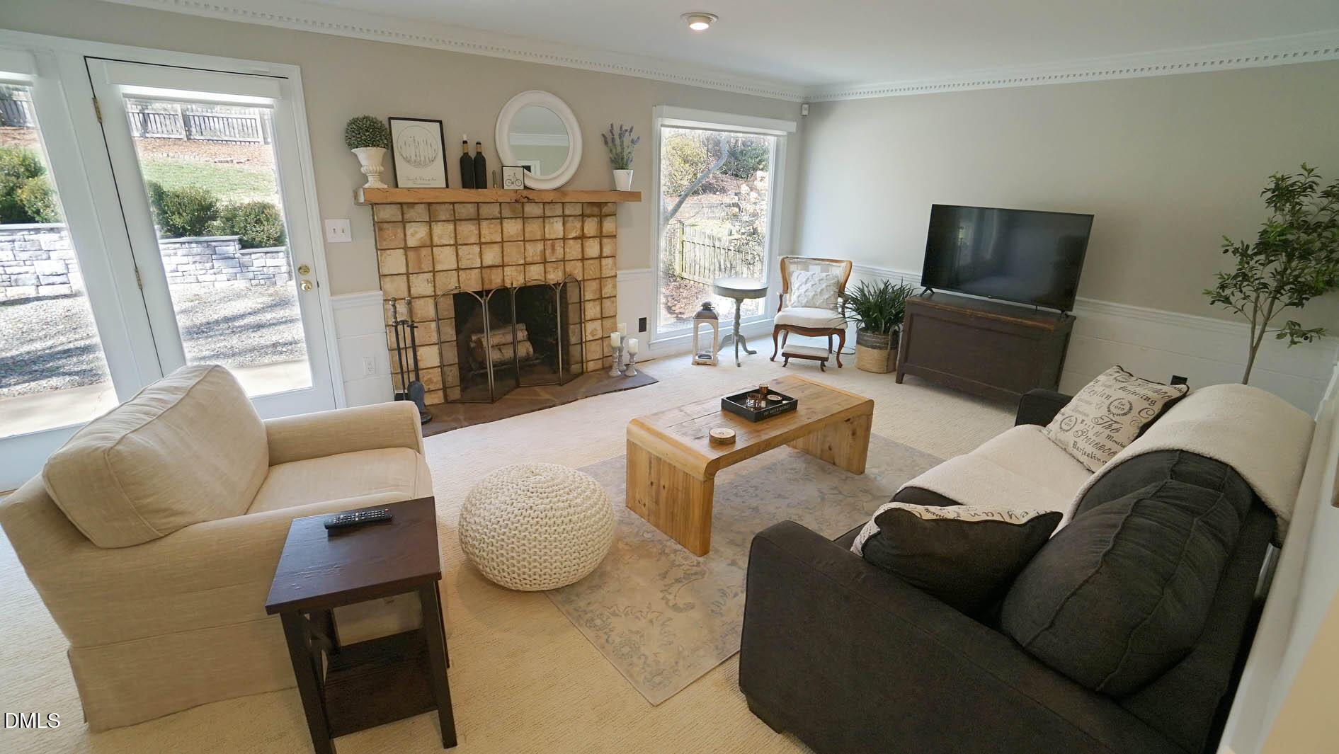 8613 Windjammer Drive Raleigh, NC 27615 - Photo 13 of 52 a living room with furniture a fireplace a flat screen tv and a large window