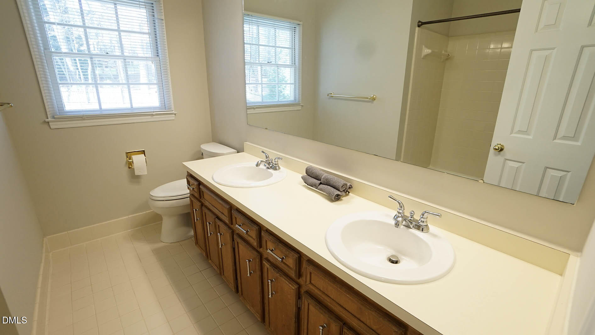 8613 Windjammer Drive Raleigh, NC 27615 - Photo 31 of 52 a bathroom with a double vanity sink toilet and a mirror
