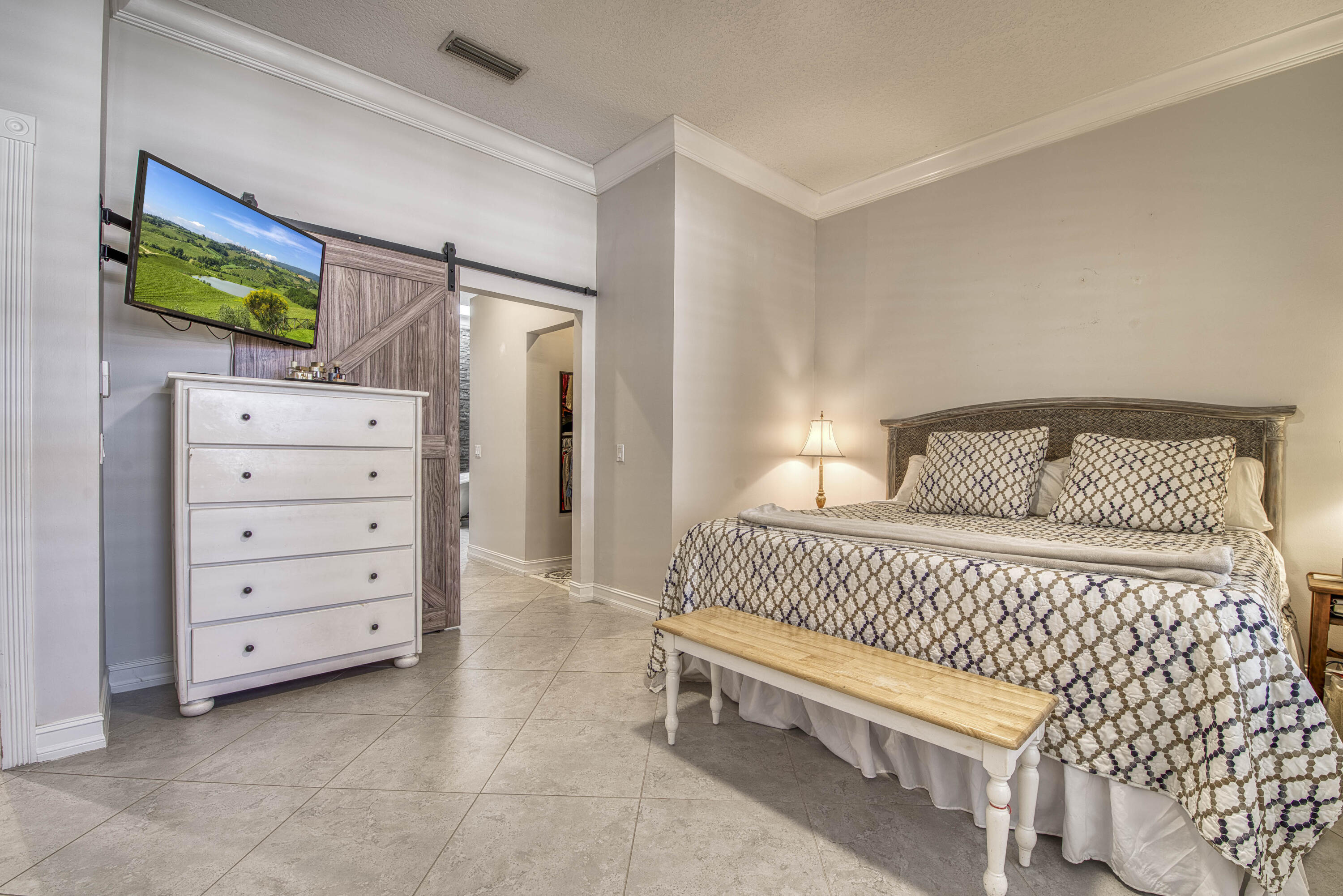 118 East Hampton Way Jupiter, FL 33458 - Photo 22 of 42 a bedroom with a bed and a flat screen tv