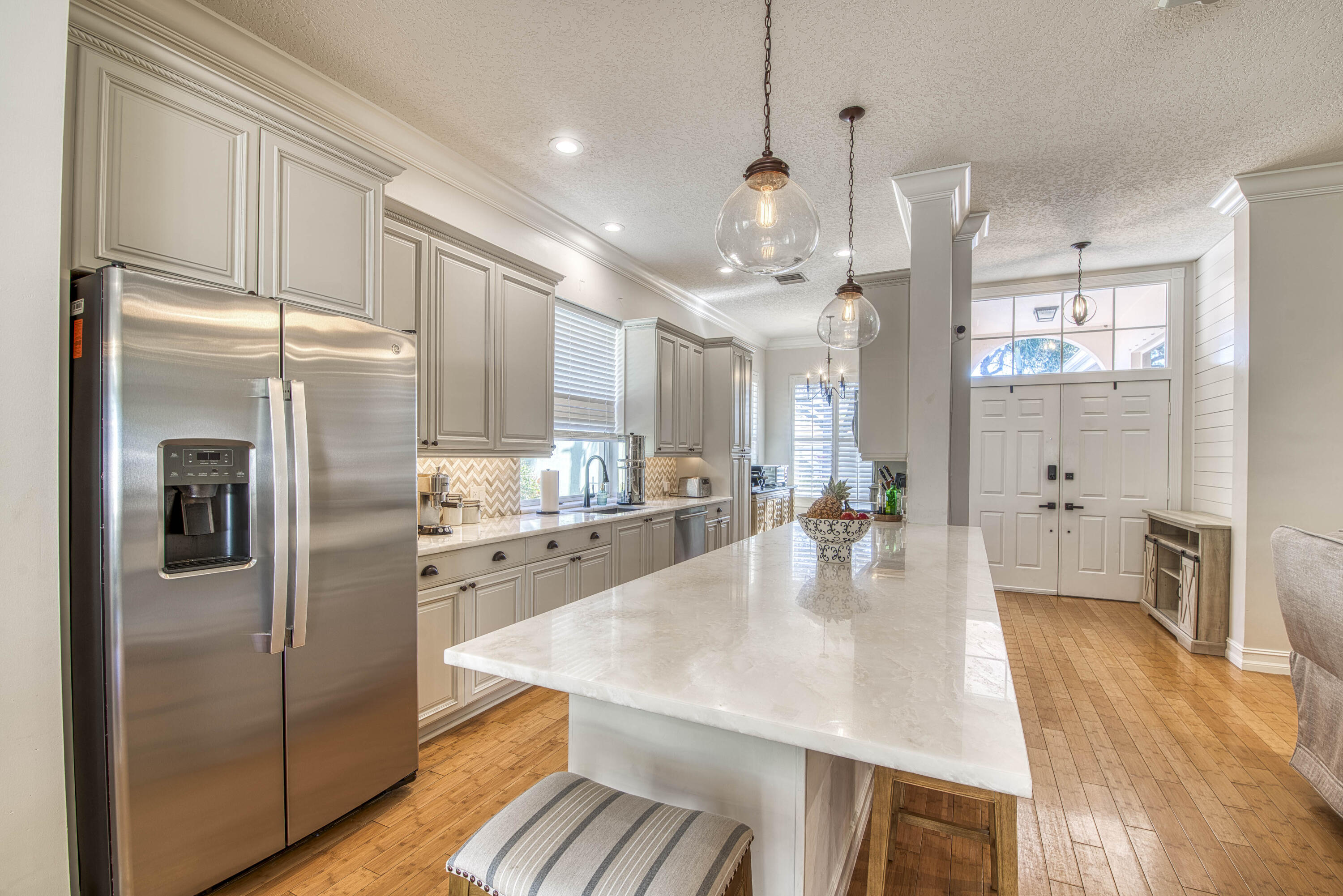 118 East Hampton Way Jupiter, FL 33458 - Photo 10 of 42 a kitchen with stainless steel appliances granite countertop a refrigerator a sink a stove and white cabinets with wooden floor