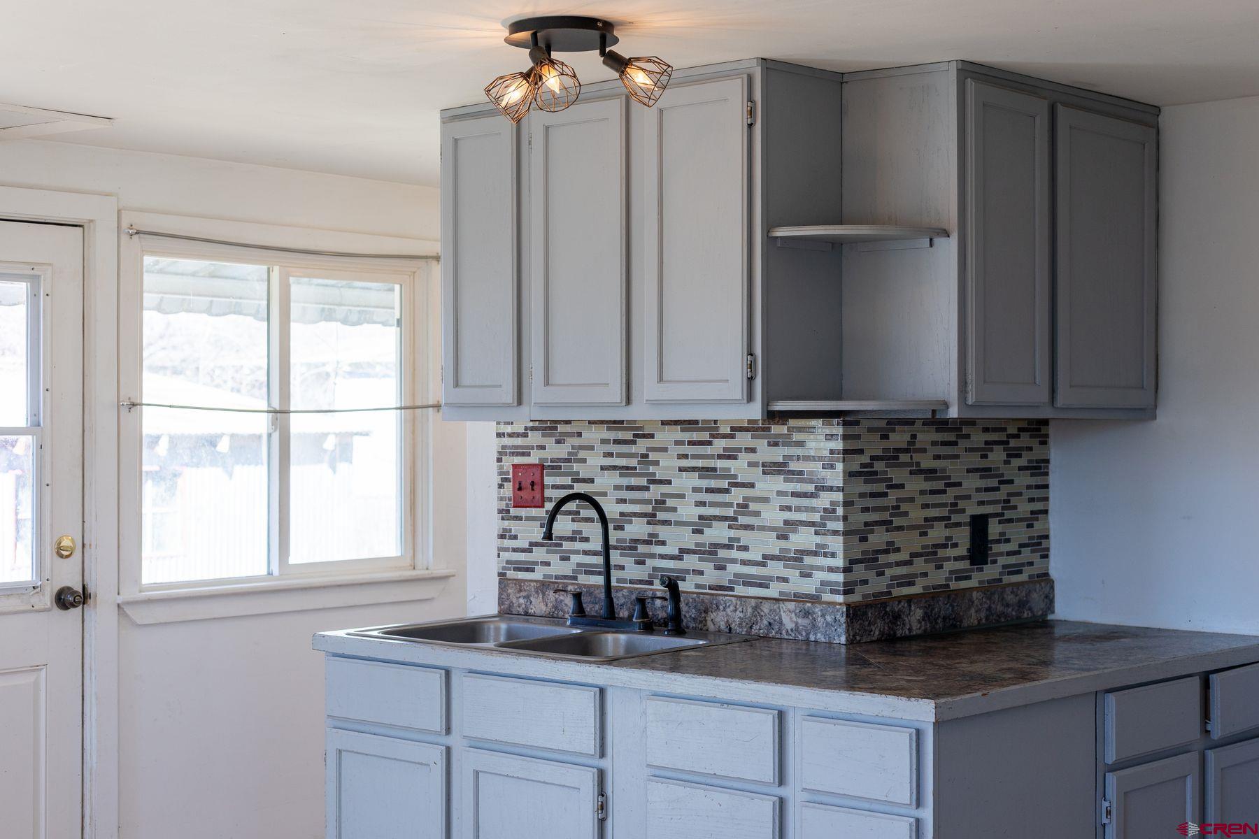 690 Grape Street Nucla, CO 81424 - Photo 6 of 24 a kitchen with granite countertop white cabinets and window