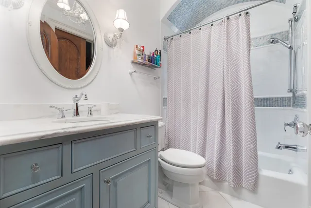 a bathroom with a toilet a sink a mirror a bathtub and shower