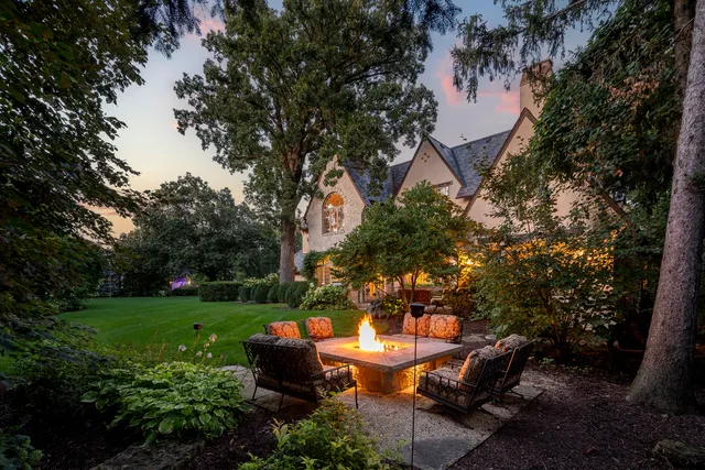 a view of a patio with table and chairs and a large tree