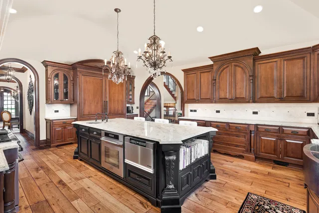 a kitchen with stainless steel appliances granite countertop a stove and a wooden floors