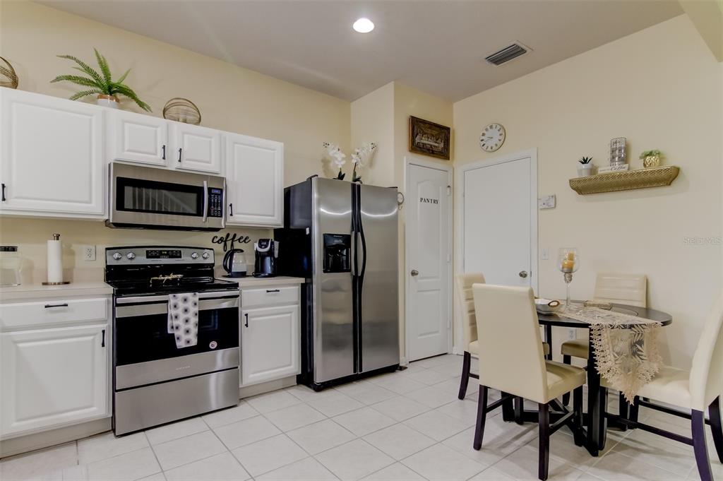 26642 Castleview Way Wesley Chapel, FL 33544 - Photo 12 of 50 a kitchen with stainless steel appliances a stove a sink island and a refrigerator
