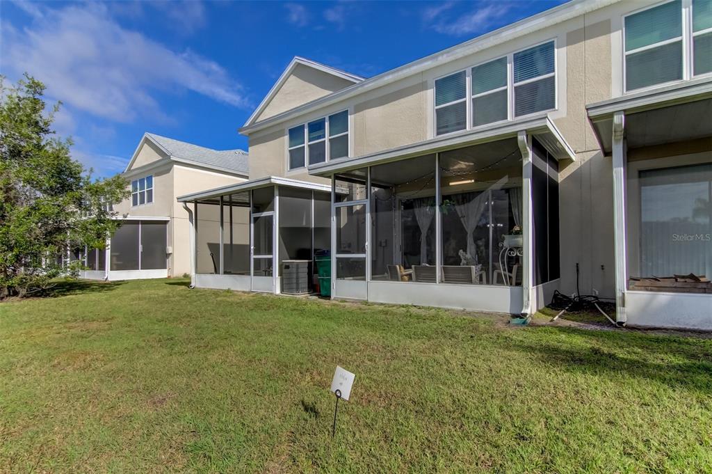 26642 Castleview Way Wesley Chapel, FL 33544 - Photo 39 of 50 a view of a white house with a large windows and a yard with plants and large trees