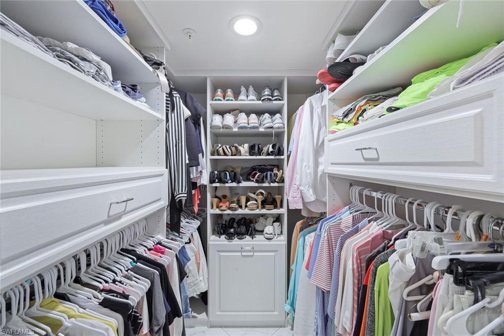 50 Seagate Drive, Unit 703 Naples, FL 34103 - Photo 22 of 34 a view of walk in closet with clothes and shoes