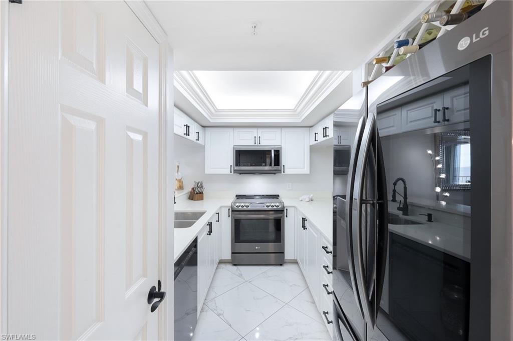 50 Seagate Drive, Unit 703 Naples, FL 34103 - Photo 5 of 34 a large kitchen with a stove and a refrigerator