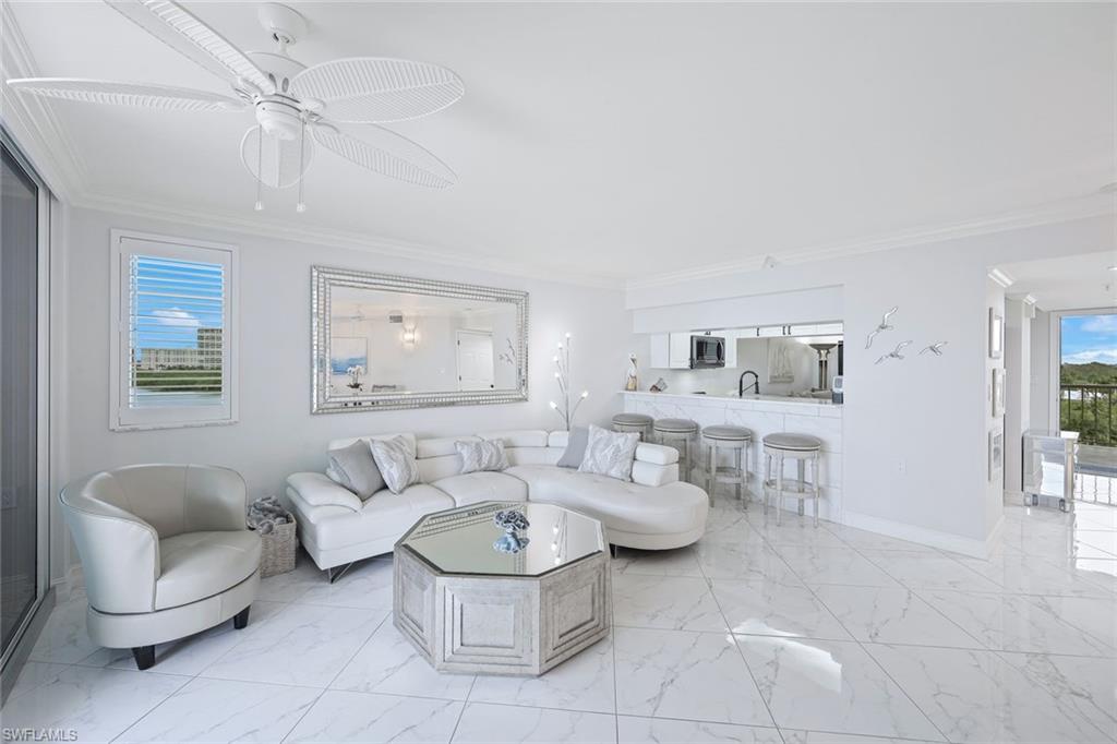 50 Seagate Drive, Unit 703 Naples, FL 34103 - Photo 7 of 34 a living room with furniture and a large window