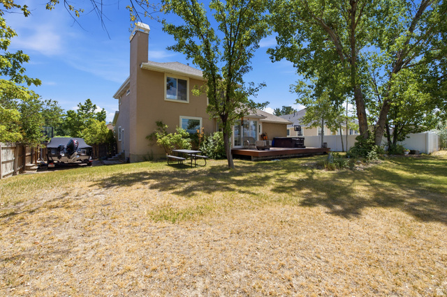 5788 Walden Ridge Drive Murray, UT 84123 - Photo 29 of 29 Expansive backyard featuring a multi-level wooden deck, mature trees providing shade, and a hot tub