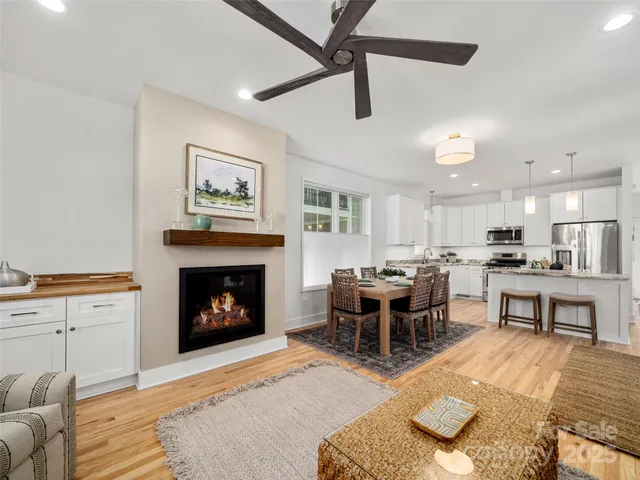 a living room with furniture a fireplace and a kitchen