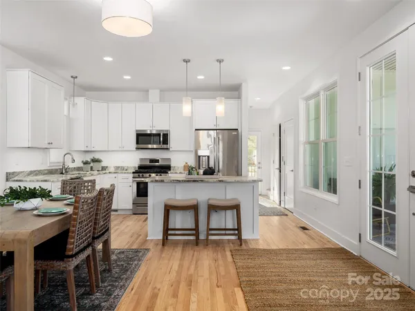 a kitchen with stainless steel appliances granite countertop a stove top oven a sink and a refrigerator