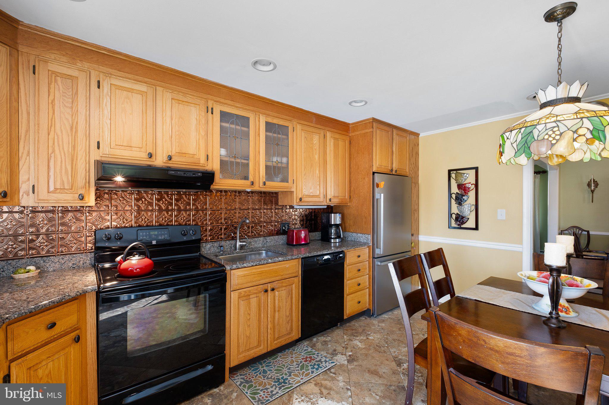 2124 Wrexham Road Wilmington, DE 19810 - Photo 10 of 28 a kitchen with stainless steel appliances granite countertop a stove a refrigerator a sink dishwasher a dining table and chairs with wooden floor