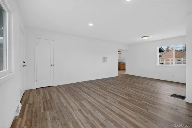 a view of empty room with wooden floor