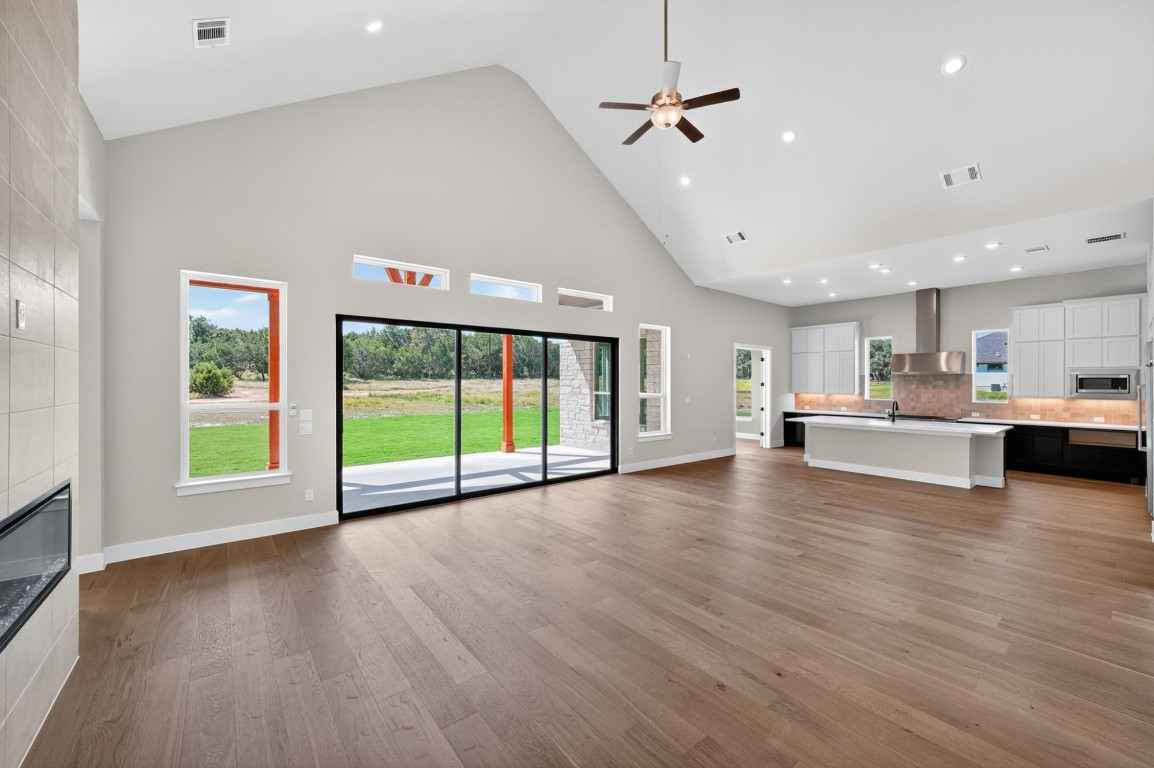 205 Three Rivers Road Georgetown, TX 78633 - Photo 4 of 32 a view of an empty room with wooden floor and a kitchen