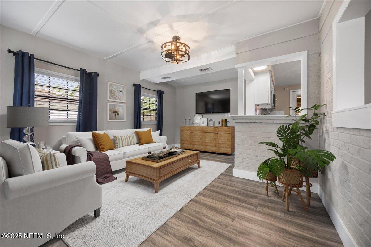 9379 Orme Road Jacksonville, FL 32220 - Photo 1 of 19 a living room with furniture a chandelier a fireplace and a flat screen tv