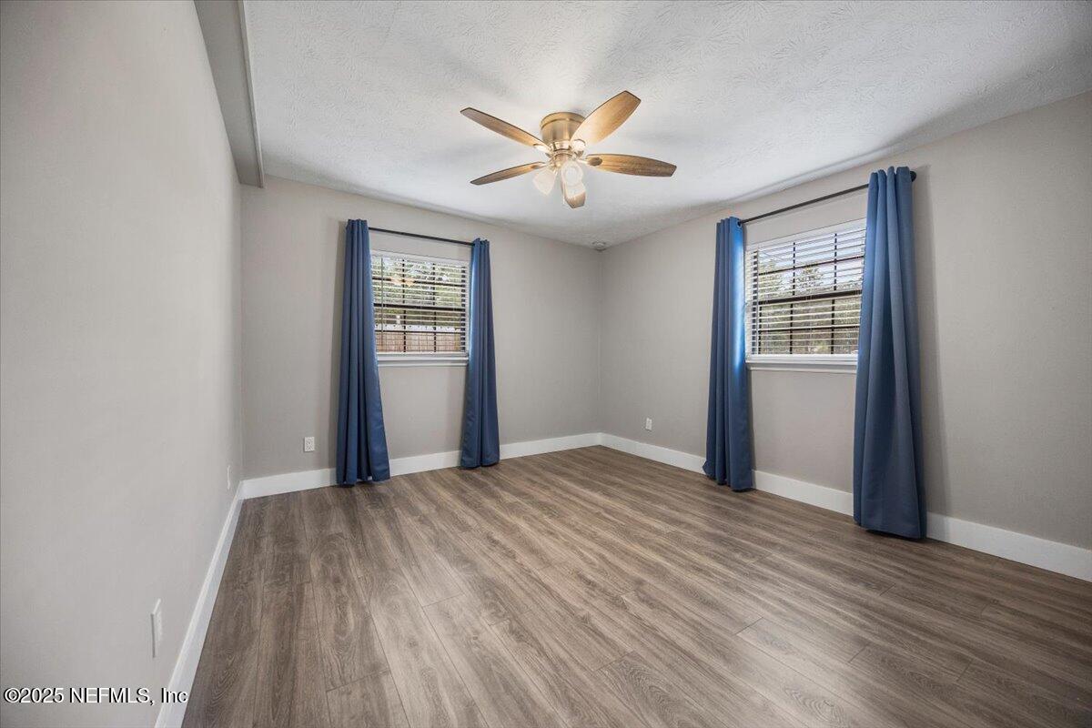 9379 Orme Road Jacksonville, FL 32220 - Photo 11 of 19 a view of an empty room with wooden floor and a window