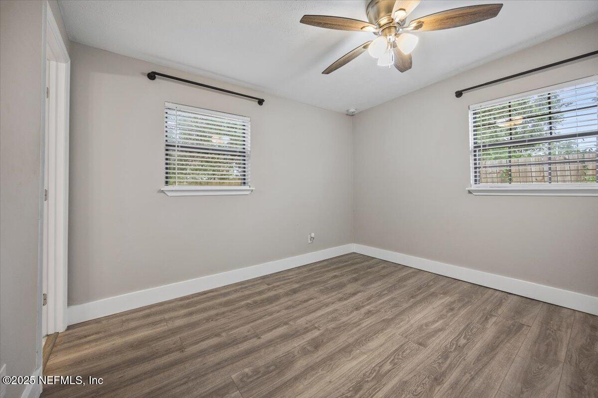 9379 Orme Road Jacksonville, FL 32220 - Photo 12 of 19 a view of an empty room with wooden floor and a window