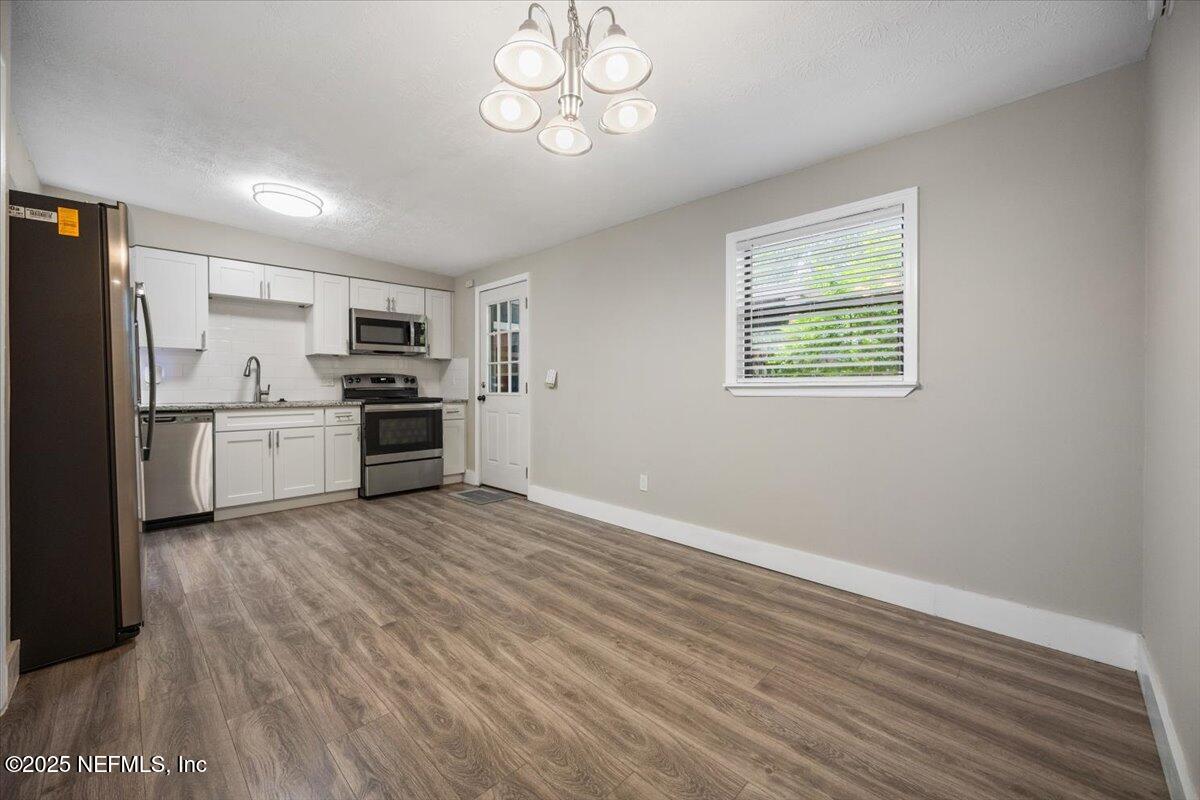 9379 Orme Road Jacksonville, FL 32220 - Photo 6 of 19 a kitchen with stainless steel appliances a stove top oven a refrigerator cabinets and wooden floor