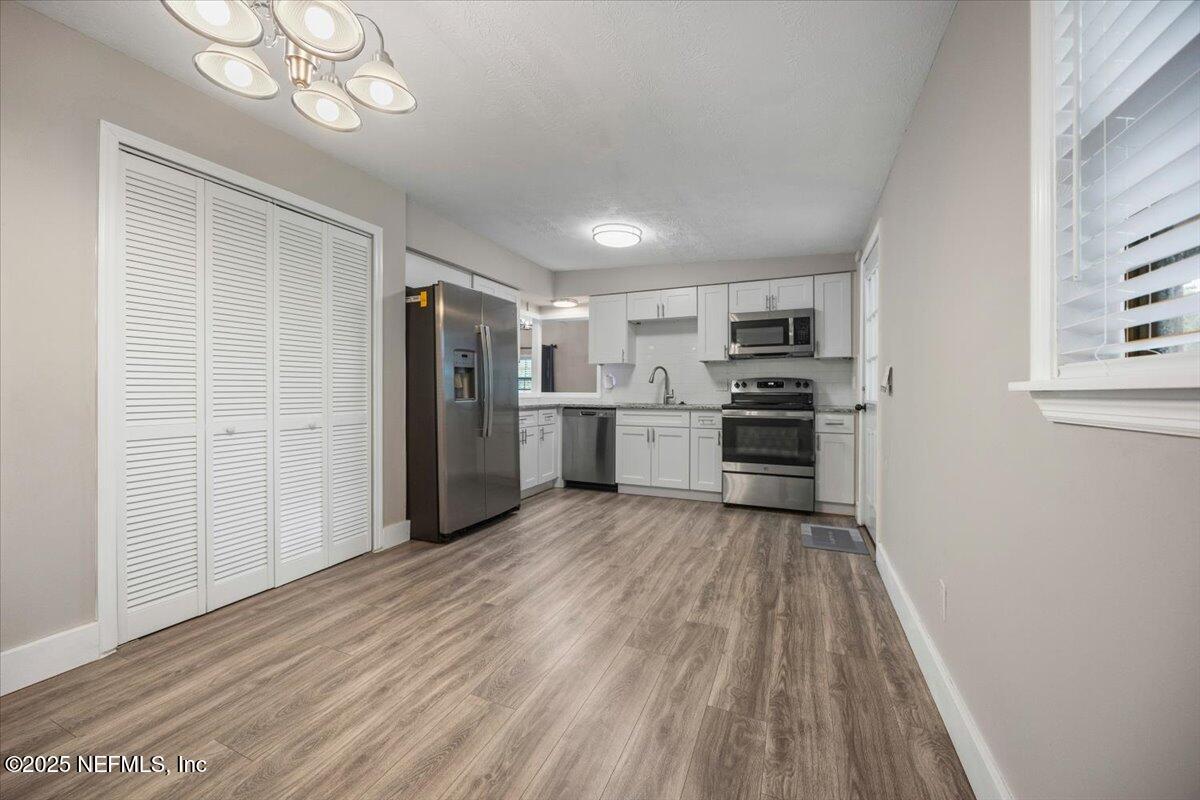 9379 Orme Road Jacksonville, FL 32220 - Photo 7 of 19 a view of a kitchen with wooden floor electronic appliances and cabinets