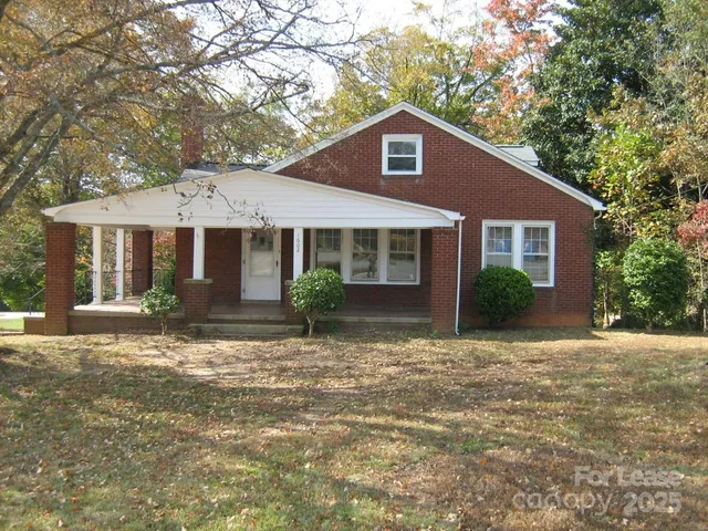 a front view of a house with yard and green space
