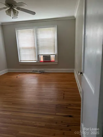 a view of empty room with window and wooden floor