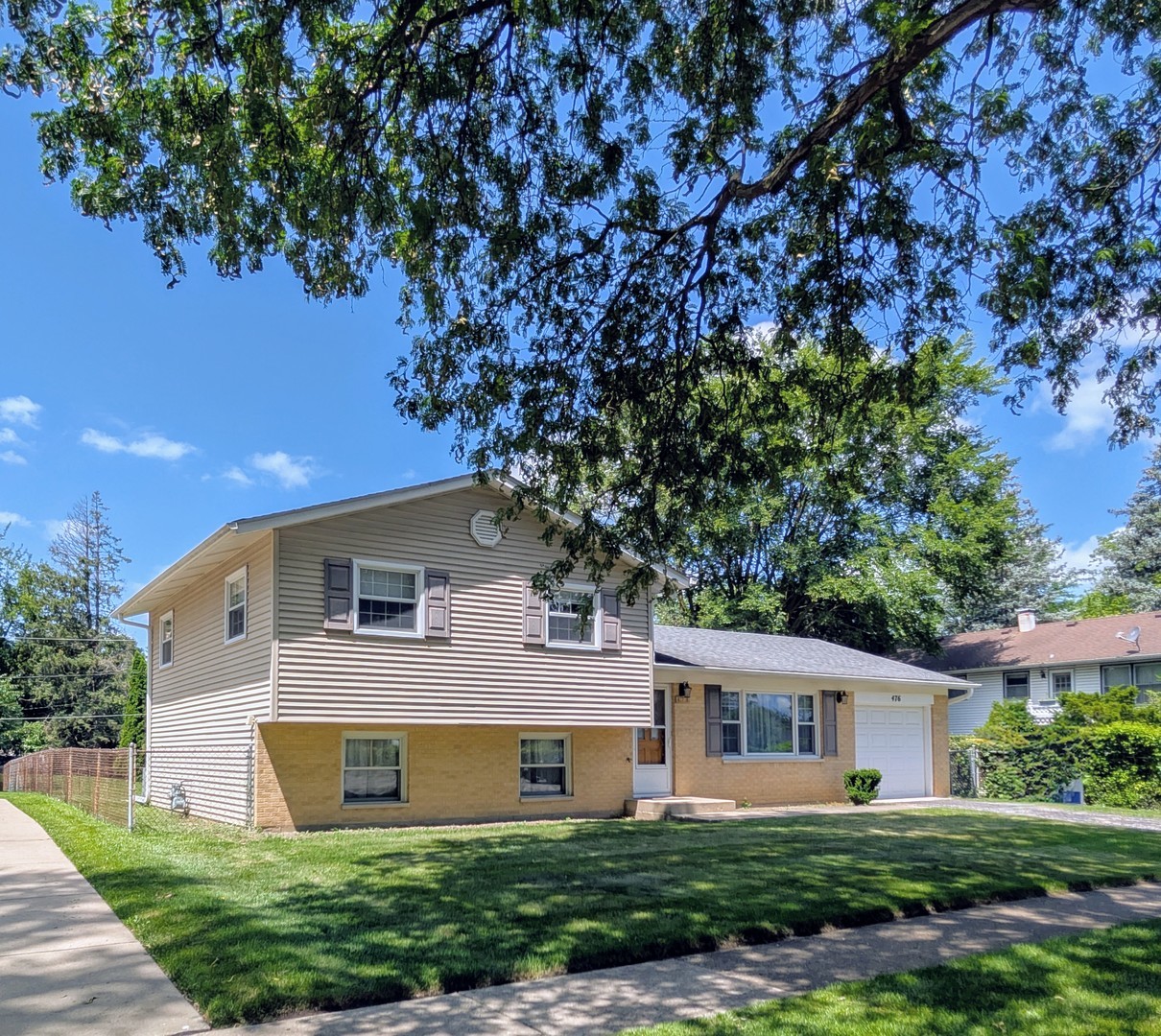 a front view of a house with a yard and trees