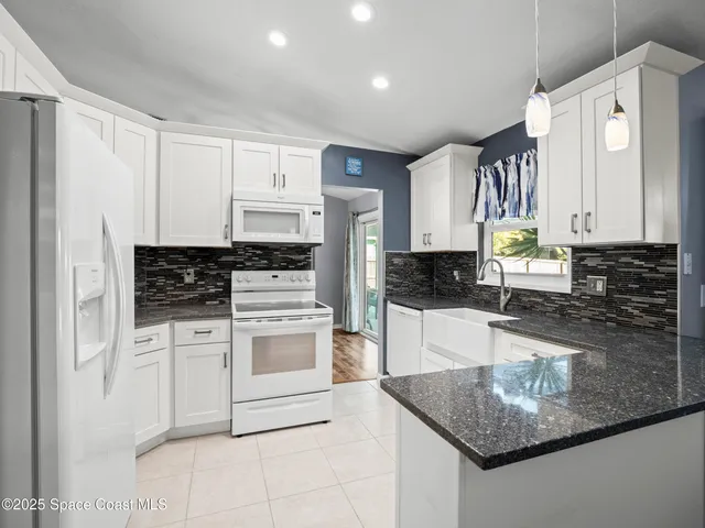 a kitchen with stainless steel appliances granite countertop a sink a stove a refrigerator a microwave and cabinets