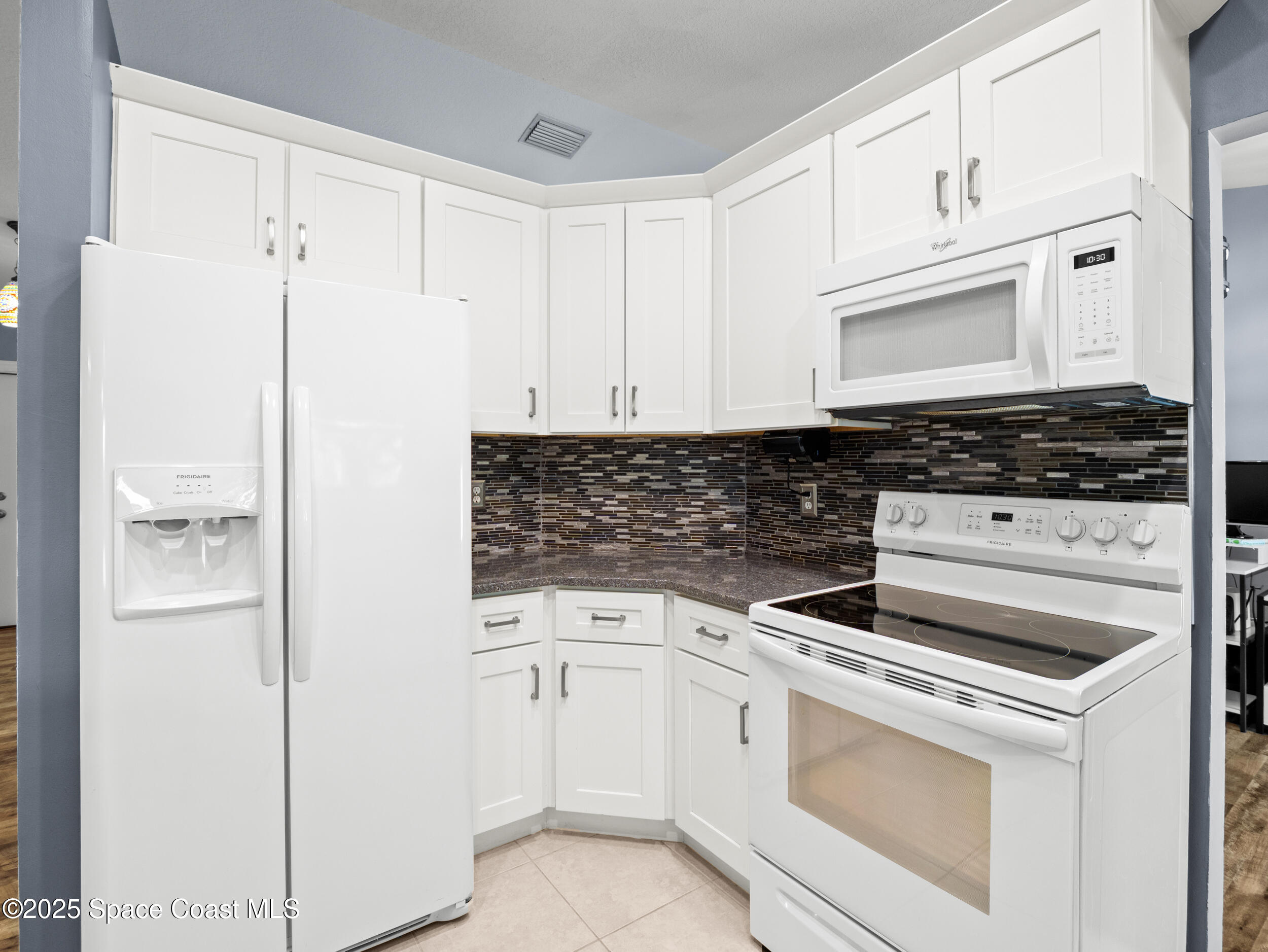 402 Watercrest Street Sebastian, FL 32958 - Photo 16 of 40 a kitchen with white cabinets and white appliances