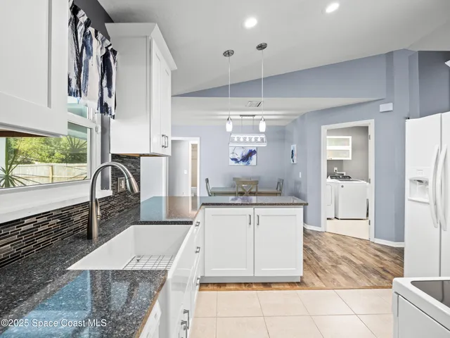 a kitchen with a sink dishwasher a stove and a refrigerator with wooden floor