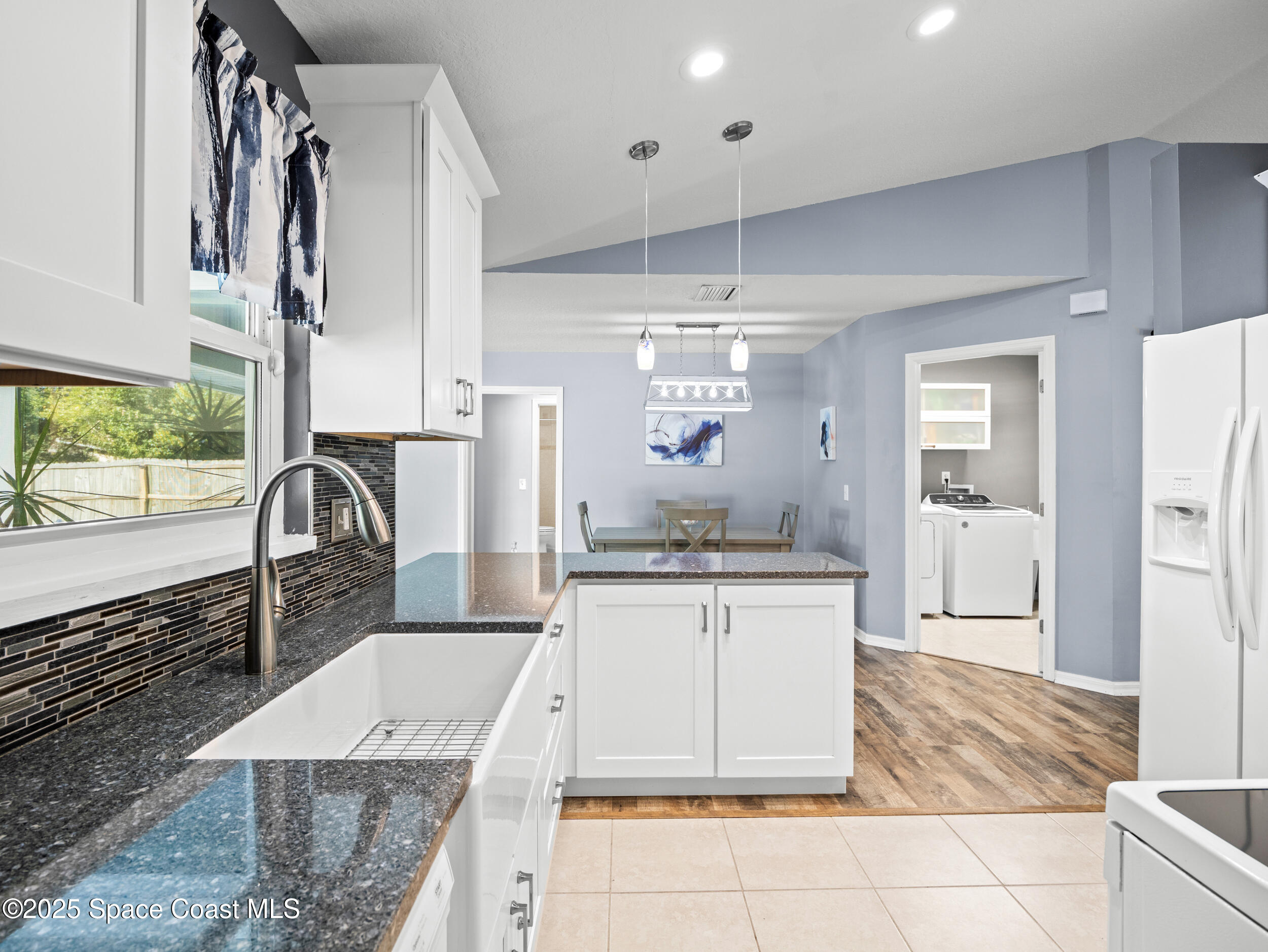 402 Watercrest Street Sebastian, FL 32958 - Photo 17 of 40 a kitchen with a sink dishwasher a stove and a refrigerator with wooden floor